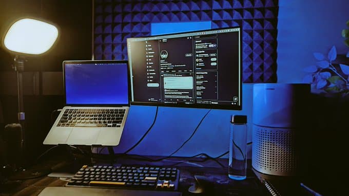 Workspace setup with laptop, monitor, and notebook